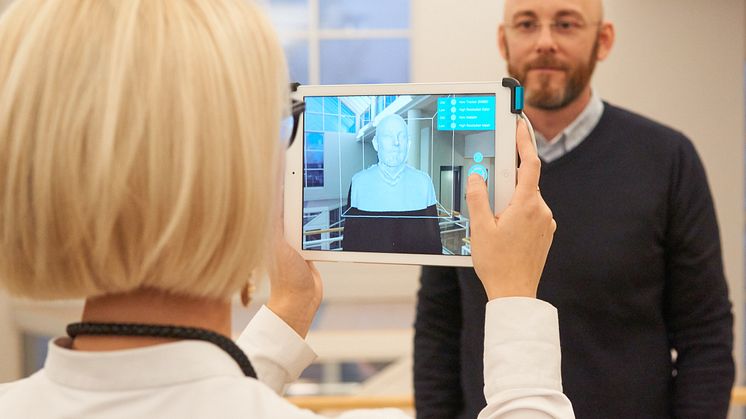 Maria Strand skannar in Kenth Johansson med en 3D-sensor monterad på en Ipad.