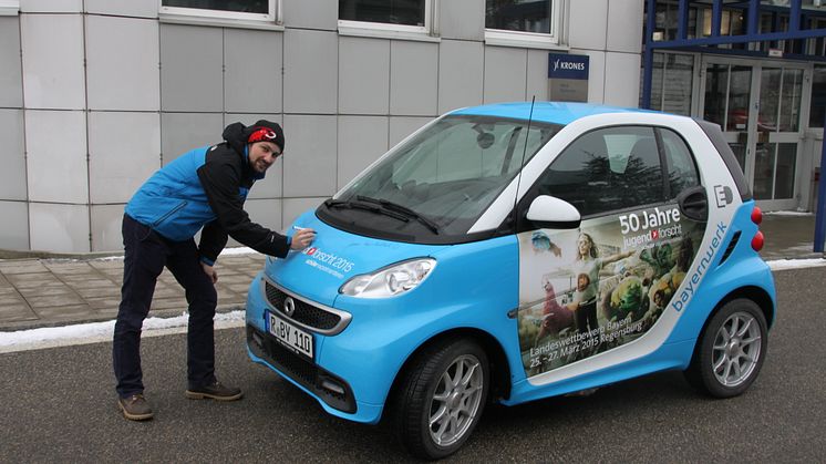 Foto: Mit dem „50 Jahre Jugend forscht E-Smart“ trifft das Patenunternehmen Bayernwerk ehemalige bayerische Preisträger, hier Lukas Kerner, und lässt diese das Elektroauto signieren.