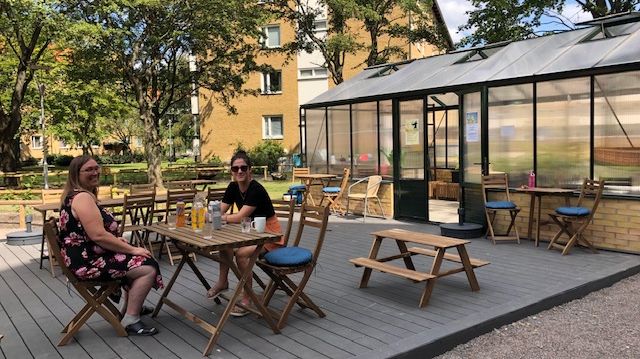 Ingela som bor i Nyadala fikar med Sofia från MKB på det nya trädäcket utanför växthuset. Alla som bor här är välkomna att sätta ut möbler och umgås.
