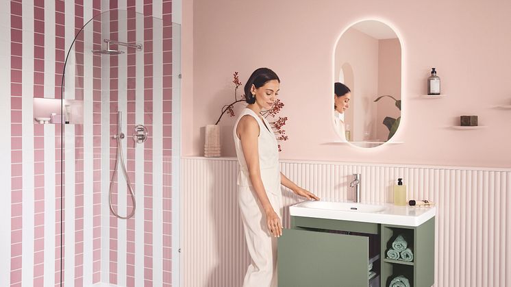 Eine Frau ist in ihrem Lifestyle-Badezimmer von Villeroy & Boch zu sehen und öffnet die Schublade vom Unterschrank.
