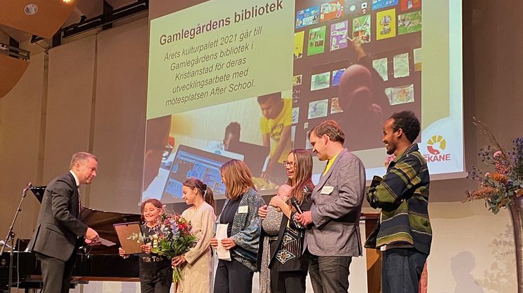 Magnus Lunderquist, ordförande i kulturnämnden Region Skåne delar ut priset till Alma Abuzarad, Edina Cosabic, Ilona Geiger, Sarah Granholm och Alva, Alexander Magnusson och Hassan Ali Mahmoud