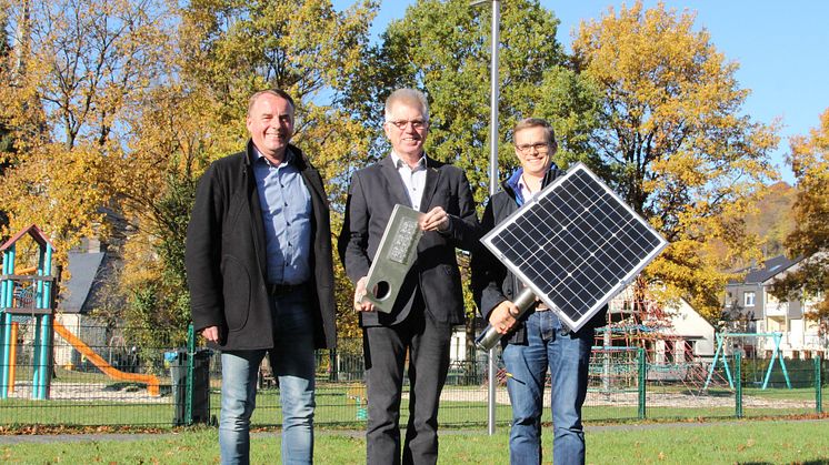 Andreas Ruprecht, Bereichsleiter Beleuchtung WWN, Bürgermeister Hans Jürgen Wessels und Florian Wiesing, Projektleiter Straßenbeleuchtung WWN mit den Hauptkomponenten der Solarleuchte.