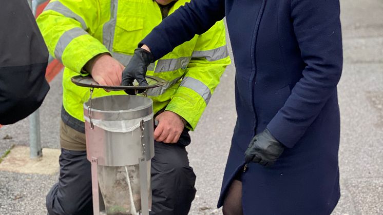 Idrottsborgarråd Karin Ernlund (C) inspekterar en granulatfälla vid Hammarbyhöjdens bollplan. Med en grönblå miljonsatsning ska 50 idrottsanläggningar förses med granulatfällor under 2020 för att minska mikroplaster i Stockholms vatten.