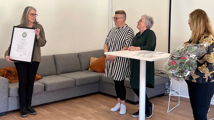 Inramad utmärkelse och blommor.