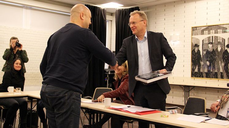 Raymond Johansen på besøk i Bydel Sagene. Her får han boken Livet langs elva av bydelsutvalgsleder Helge Stoltenberg (Foto: Boligbygg)