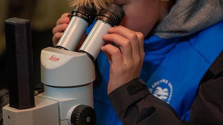 Skoleelev med mikroskop