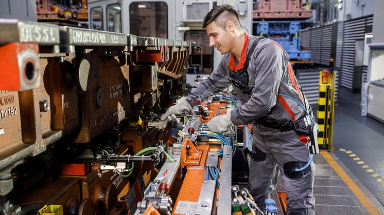 When preparing the transfer press, an employee uses the exoskeleton in the press shop at the Neckarsulm plant