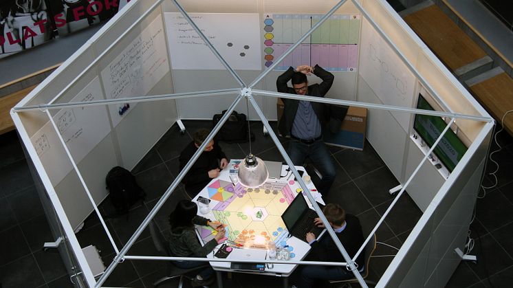 De fyra studenterna i intensivt arbete runt "spelplanen" som tar dem framåt i innovationsprocessen.