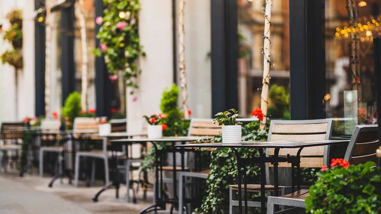 Bilden visar en restaurangs uteservering utsmyckad med blommor och växter (bild från Shutterstock)