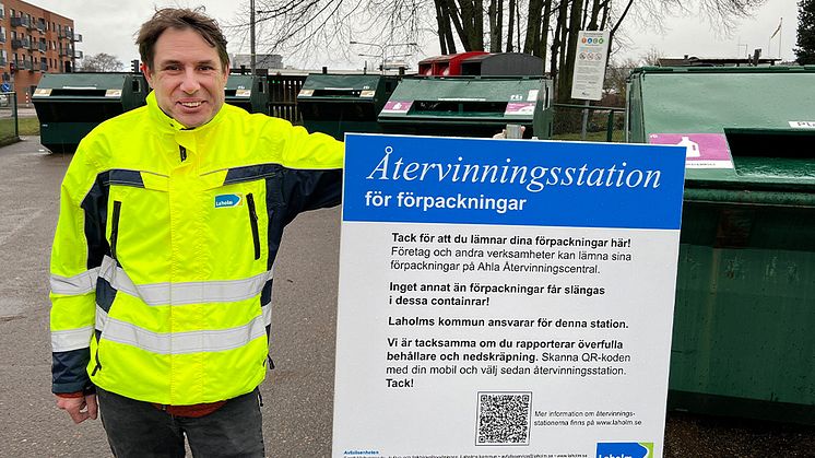 Daniel Zetreus, avfallsplanerare i Laholm, vid återvinningsstation med ny informationsskylt.