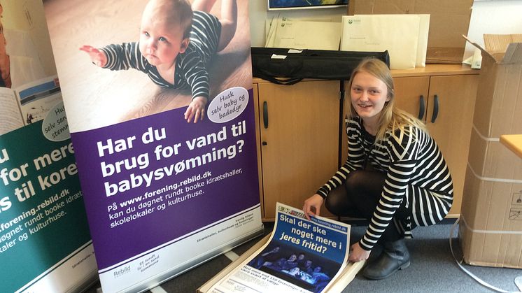 Kontorelev Janni Karlsen er i fuld sving med at pakke plakater og bannere som i den kom-mende tid skal reklamere for den nye portal. Foto: Rebild Kommune