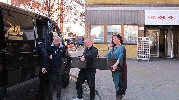 Aida Alakrawi, verksamhetsansvarig för Barn till ensamma mammor och Nikola Asancaic från Fryshuset tar emot dagens lunch som levereras av Harun Ileri och Mahmoud Gazawi från restaurang Laziza i Dockan, Malmö.