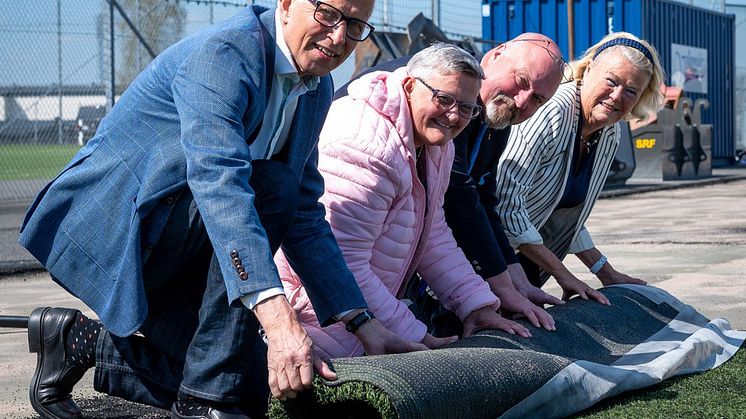 Sven Olof Bernhoff VD Skånefrö, Connie Asterman (S), Paul Thurn (SD) och Margreth Segerstein (M) från Kultur- och Fritidsnämnden rullar gemensamt upp gräsmattan på Österås IP – ett annorlunda första spadtag. Foto: Thomas Bengtsson, Fri Kommunikation