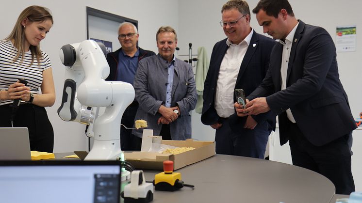 Auch bei der Abschlussveranstaltung konnten die Anwesenden noch einmal die Roboter hautnah erleben - hier serviert der CoBot ein Stück Kuchen.