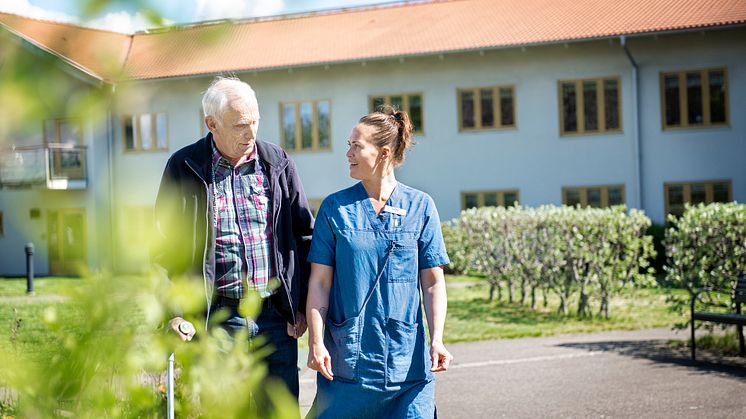 Anställd promenerar och pratar med omsorgstagare_KungsbackaKommun