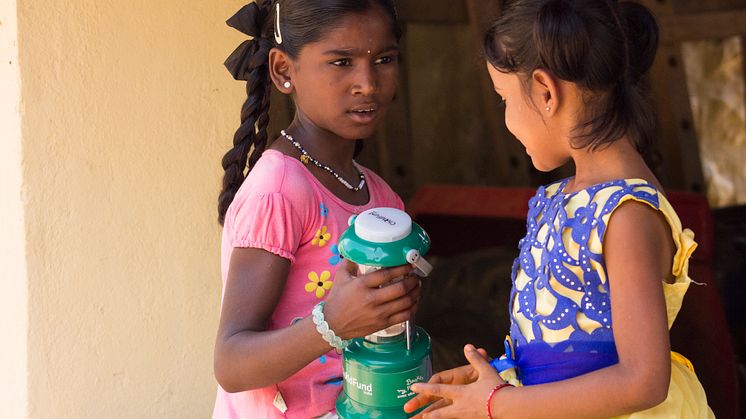 Prathibha och Swathi med familjens solcellslampa