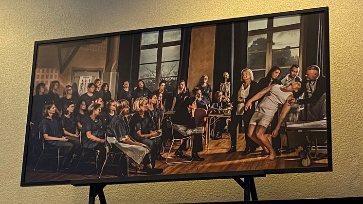 Tavlan En klinisk lektion vid Högskolan Väst hänger på Högskolan Väst i Trollhättan, ovanför entrén till Restaurang Västan.
