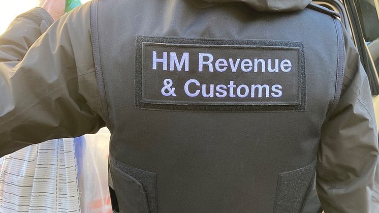 An HMRC officer seizes evidence, following a coordinated operation across England into large-scale tax repayment fraud