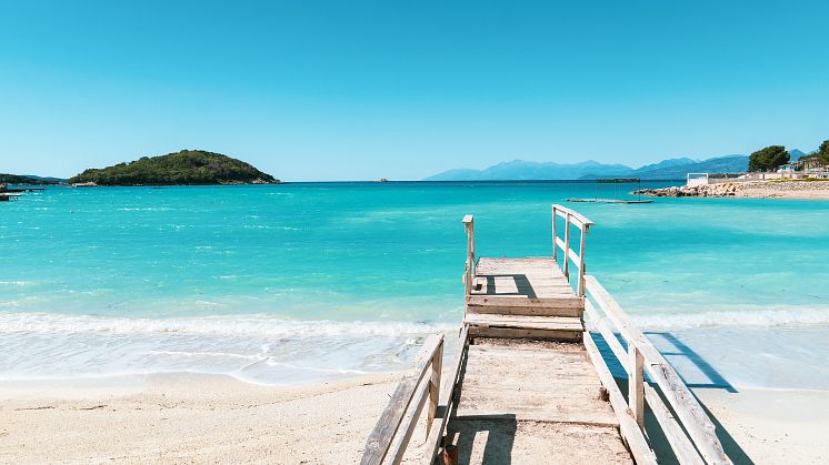 Rimelige feriedestinasjoner som også tilbyr kritthvite strender og turkist vann. Foto av nasjonalparken Ksamil i Albania. 