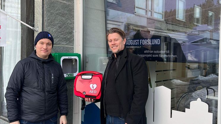 Willy Runnzell, affärsområdeschef på HSB Södra Norrland och Christer Karlsson på Plusab Medical Solution vid hjärtstartaren utanför HSBs kontor i Östersund.