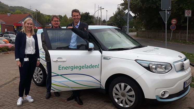 Leonie Riekschnitz, Kommunalreferentin Westfalen Weser Netz, übergibt den Elektrowagen an Bürgermeister Clemens Pommerening (r.) und Peter Gehrke.