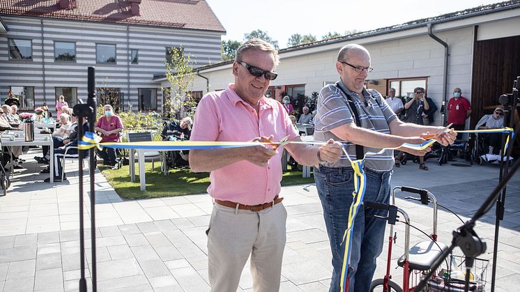 Roland Karlsson, ordförande i Kooperativa Hyresrättsföreningen (KHF) Lysekils omsorgsbostäder och Ulf Oskarsson, boende, klipper bandet i samband med invigningen. Foto: Gabriel Berndtsson, Lysekilsposten
