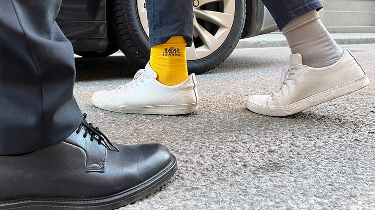 En passagerare som bär Taxi Stockholms strumpor inför "Rocka sockorna"-dagen