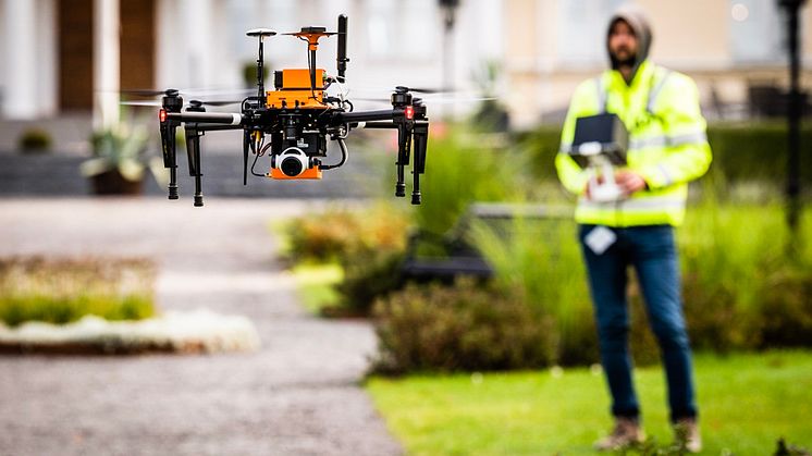 En drönare med autonoma egenskaper. I bakgrunden syns en säkerhetspilot redo att ta över kontrollen vid behov.