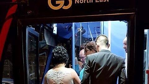 Newlyweds Kayleigh and Colin Thompson jump on-board the bus for their journey home