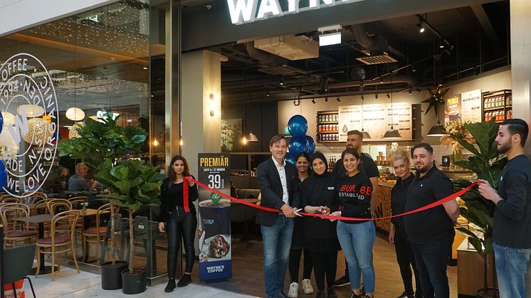 Mats Hörnell, VD Wayne's Coffee, klipper band vid premiären av Wayne's i Täby Centrum