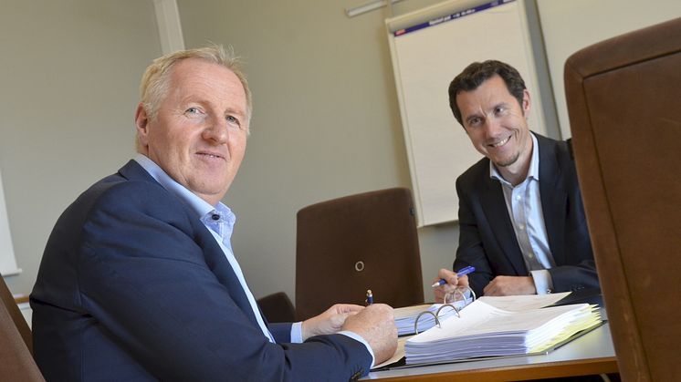 Avdelingsdirektør Torgeir Strypet hos Difi (t.v.) signerer avtalen hos Thomas Mathisen i Posten Norge.