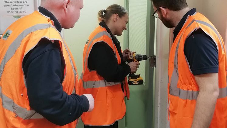 Natalie Parker repairing a toilet door at Worthing station in her first week