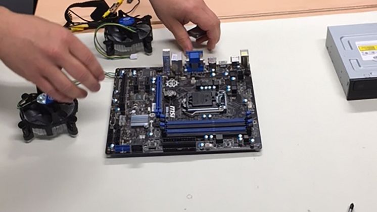 Fingerfärdiga elever från Ektorpskolan sätter ihop en dator på Realgymnasiet.