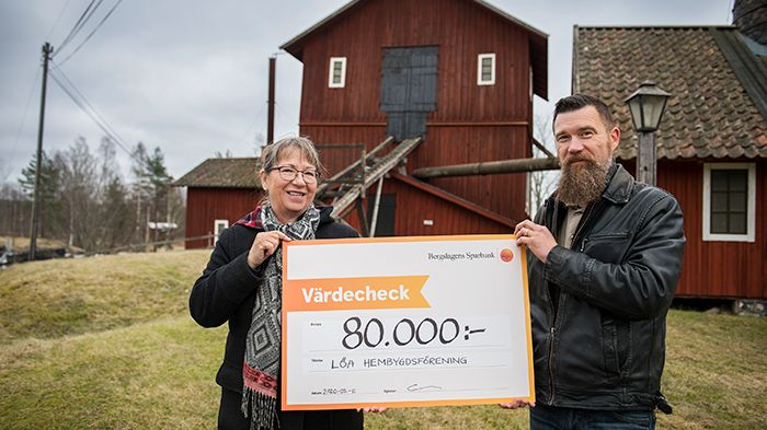 Eva Persson, projektledare för Hyttans hemligheter, tar emot check från Ola Anderberg, bankens kontorschef i Kopparberg.