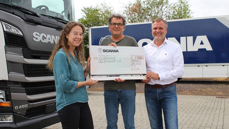 Andrea Gries (li.) und Detlev Both (r.), beide Betriebsrat Scania Deutschland, überreichen den Spendenscheck in Höhe von 1.000 Euro an Jürgen Michel (Mitte) vom Koblenzer Verein „Die Schachtel“.