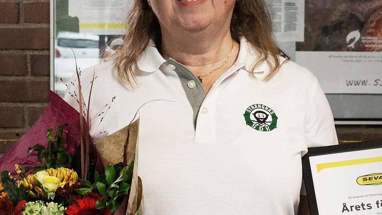 Kristina Hansen, sekreterare i Strängnäs Sportdykarklubb, tar emot blommor och diplom.