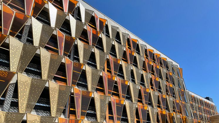 Den fjärilslika fasaden in mot Medicon Village fångar blicken på långt håll i oranget plexiglas och guldfärgad aluminium. 