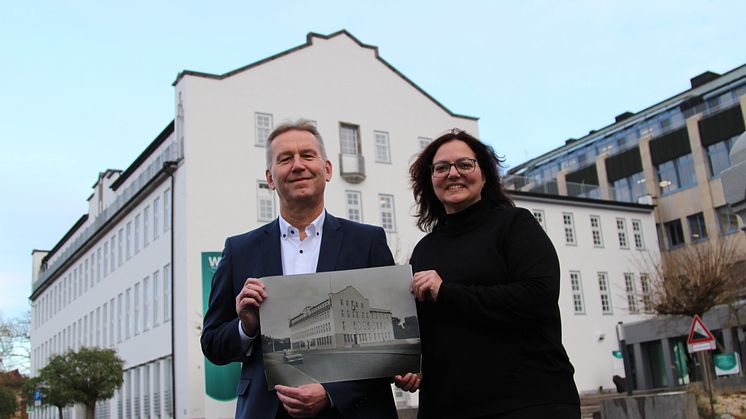 Jürgen Noch und Annemarie Marx zeigen ein Foto mit der denkmalgeschützten Fassade von 1955