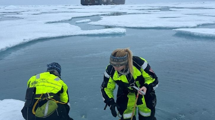 Eva Leu and Rebecca Duncan collecting algae from meltponds for measuring their productivity 