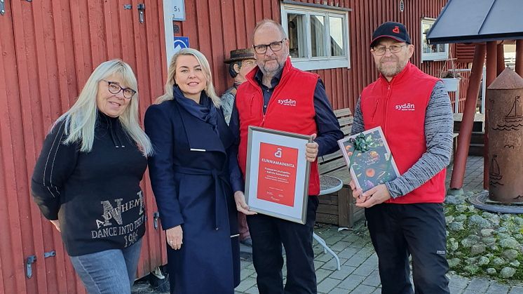 Etelä-Suomen Sydänpiirin puheenjohtaja Eero Salo ja Vuosaaren Sydänyhdistyksen puheenjohtaja Eino Päivärinta ojentavat kunniamaininnan Kahvila Kampelan Pirjo Hassiselle ja Riina Dursunille