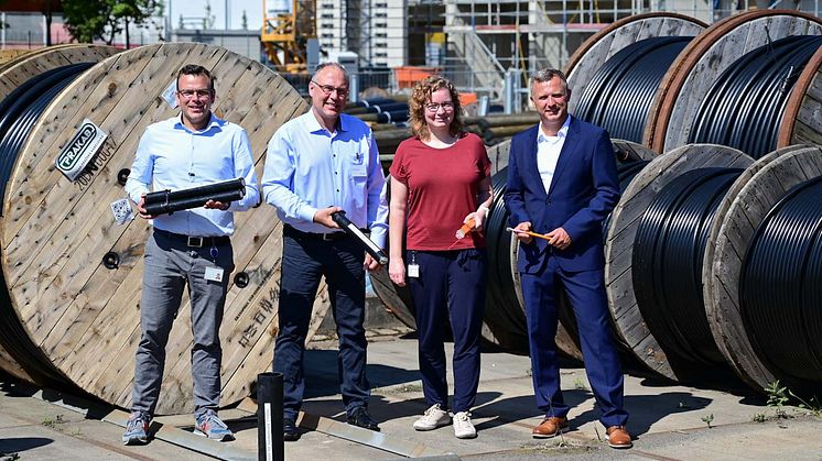 Carsten Schneider, Thomas Kotarski, Viktoria Klemens  und Bernd Göttlicher präsentieren im Lager verschiedene Kabeltypen.