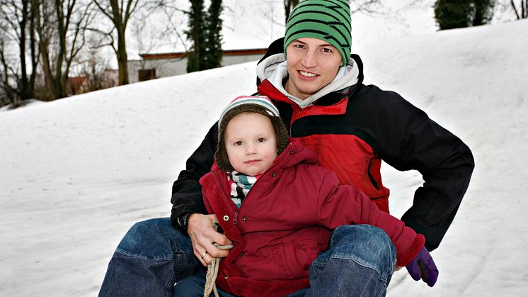 Kind mit Vater auf Schlitten
