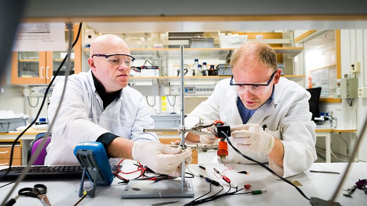 Edwin Jager vid Linköpings universitet (höger) och Nils-Krister Persson vid Högskolan i Borås (vänster) monterar en ”textil muskel” i en uppställning av mätinstrument som mäter kraft.