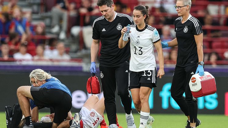 Osteopathin Birgit Halsband (r.) begleitet Nationalspielerin Sara Däbritz (M.) mit Mannschaftsarzt Tobias Schmenn (l.) beim EM-Spiel gegen Dänemark. Foto: DFB