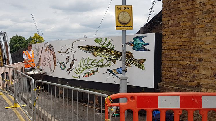 Mark Anthony of ATM Street Art painting the new mural at Palmers Green station - MORE IMAGES AVAILABLE TO DOWNLOAD BELOW