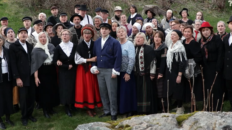 Et kor som synger, ikledd gammeldagse klær.
