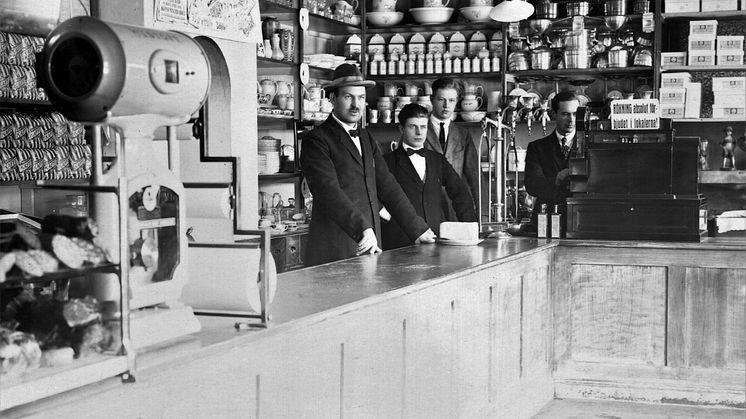 Stolta expediter i den nyöppnade konsumbutiken i Högsjö 1919. Här kan både matvaror och husgeråd köpas över disk. Ernst Hultkvist, Gunnar Aronsell, Tore Hallerström och Artur Wahlström poserar framför kameran dagen till ära. Fotograf: Okänd. Högsjö k