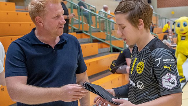 Andreas Bath von der SIGNAL IDUNA Gruppe überreichte jeder BVB-Spielerin (hier Mannschaftskapitänin Alijna Grijseels) zum Start des Sponsorings ein Präsent. Foto: BVB