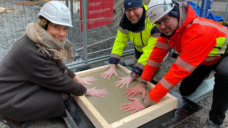 Ulrika von Wachenfeldt, projektchef på Lansa Fastigheter, Lars Kylin, vd TB-Gruppen Bostad, och Mattias Uppsäll, arbetschef på Veidekke genomför den symboliska första gjutningen. Foto: Anna Granander, Lansa Fastigheter