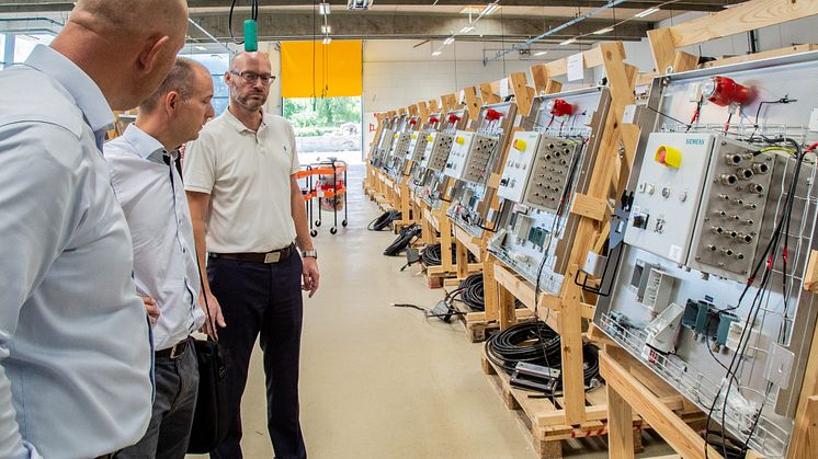Carsten Sandby Knudsen, RITTAL A/S, t.v., Martin Nørgård Nielsen, RITTAL A/S, m.f., og Lars Farsø, FH Automation A/S, t.h., betragter en serie el-tavler under opbygning til en af de større vindmølleproducenter.
